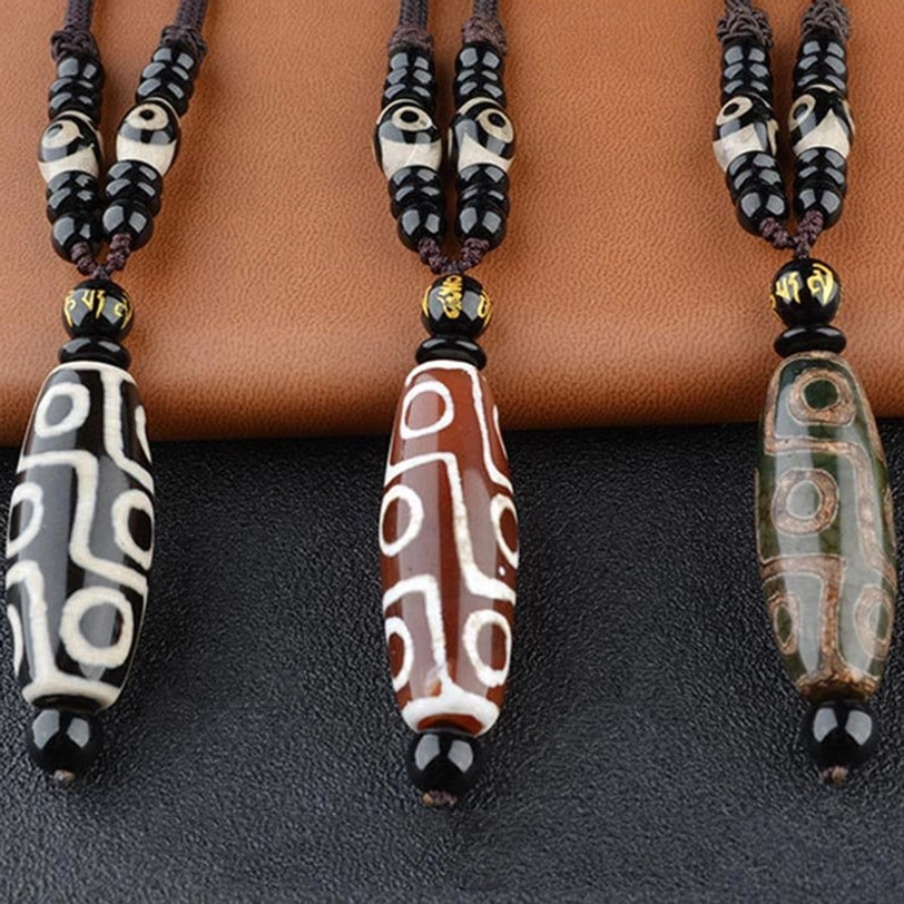Handcrafted nine-eye Dzi bead necklace detail shot highlighting authentic hand-painted agate patterns and traditional Tibetan spiritual symbols