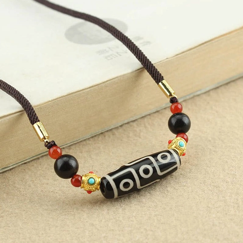 Nine-eye dzi bead necklace showing clear black-white pattern with red gold black decorative beads