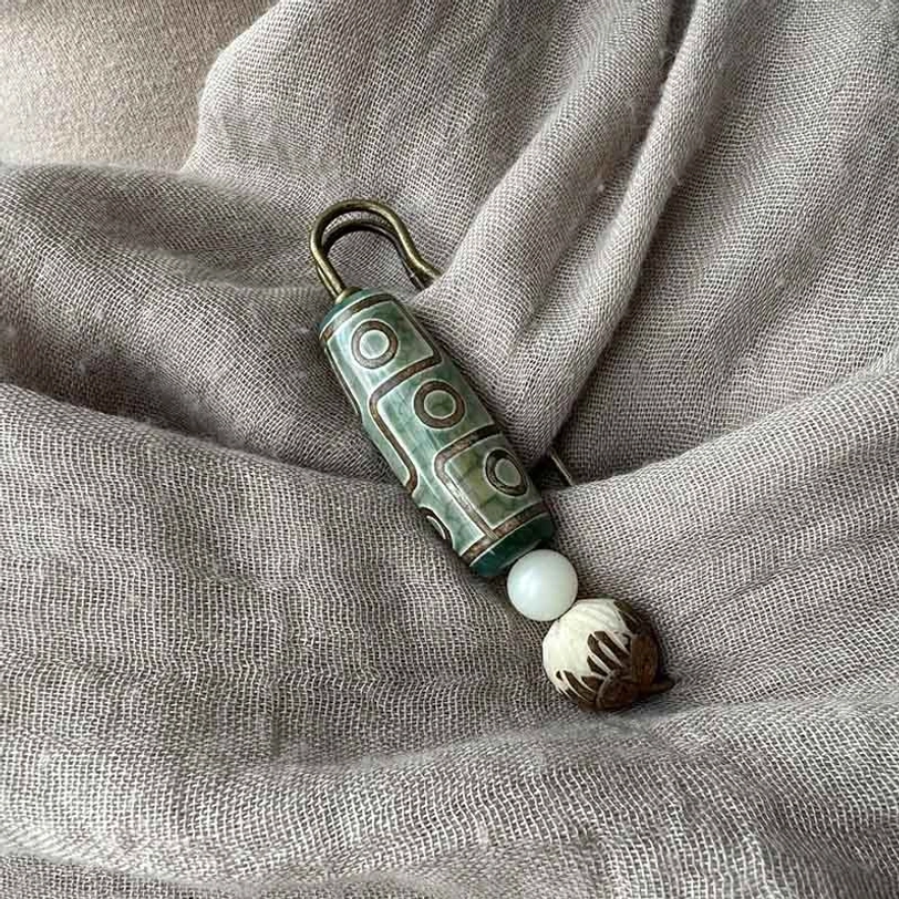 Nine-eye dzi bead bodhi seed lotus brooch multiple angle view showing carved details and craftsmanship