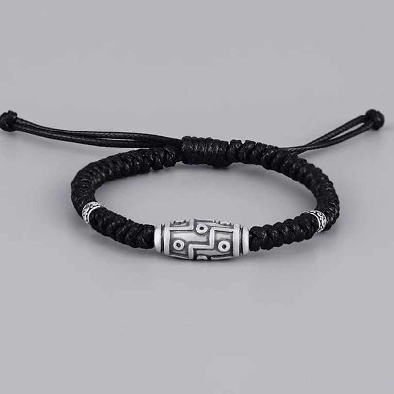 Finished nine-eye dzi bead bracelet front lay view with adjustable pull ties, complete product shot on neutral background