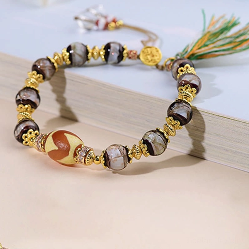 Handcrafted Dzi blessing bracelet detail shot highlighting bead craftsmanship and gold decorative accents