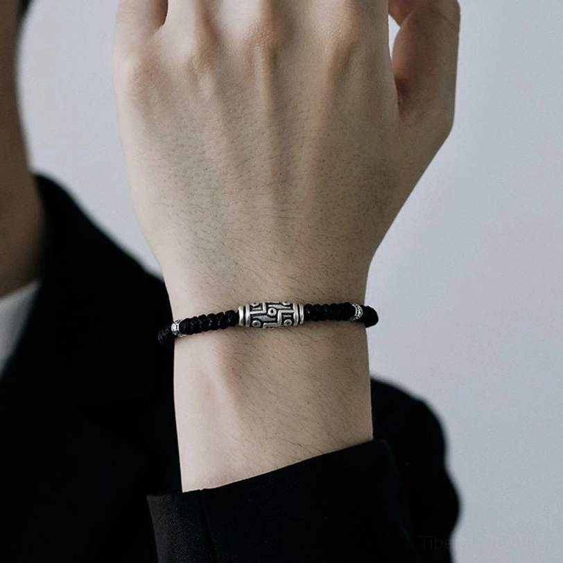 Sterling silver nine-eye dzi bead bracelet lifestyle wear shot, showing bracelet on wrist in natural light setting