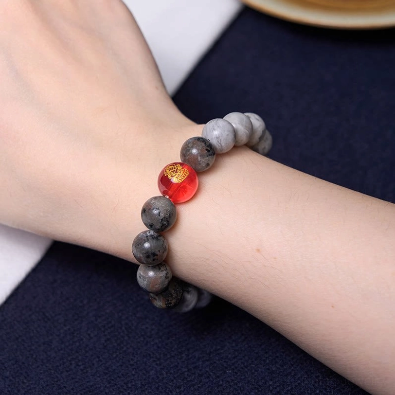 Nine-eye dzi picasso jasper bracelet worn on wrist, showing comfortable fit with grey natural stone beads and spiritual dzi amulet