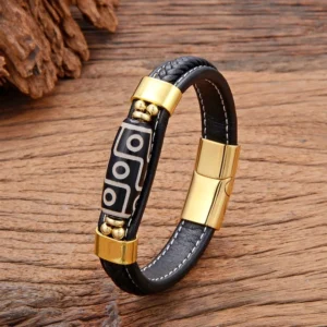 Gold-tone Nine-Eye Dzi Bead leather bracelet with accent beads, featuring adjustable buckle clasp on wooden table background
