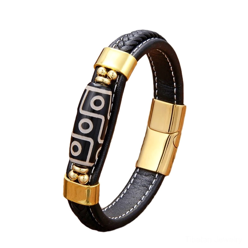 Side view of Nine-Eye Dzi Bead leather bracelet showing detailed pattern and gold-tone hardware against plain wooden background