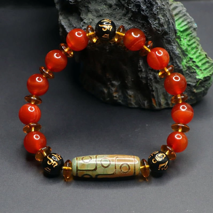 Nine-eye dzi bead red agate bracelet packaging and presentation showing sacred tibetan jewelry with protective amulet significance