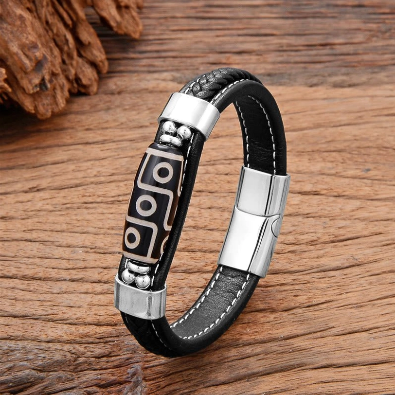 Silver-tone Nine-Eye Dzi Bead leather bracelet with silver accent beads and metal clasp on decorative wooden surface