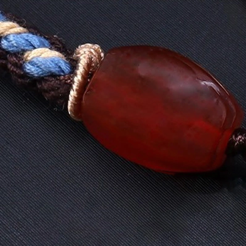 Nine-eye dzi bead tibetan necklace showing full adjustable braided cord with metal and gemstone accents