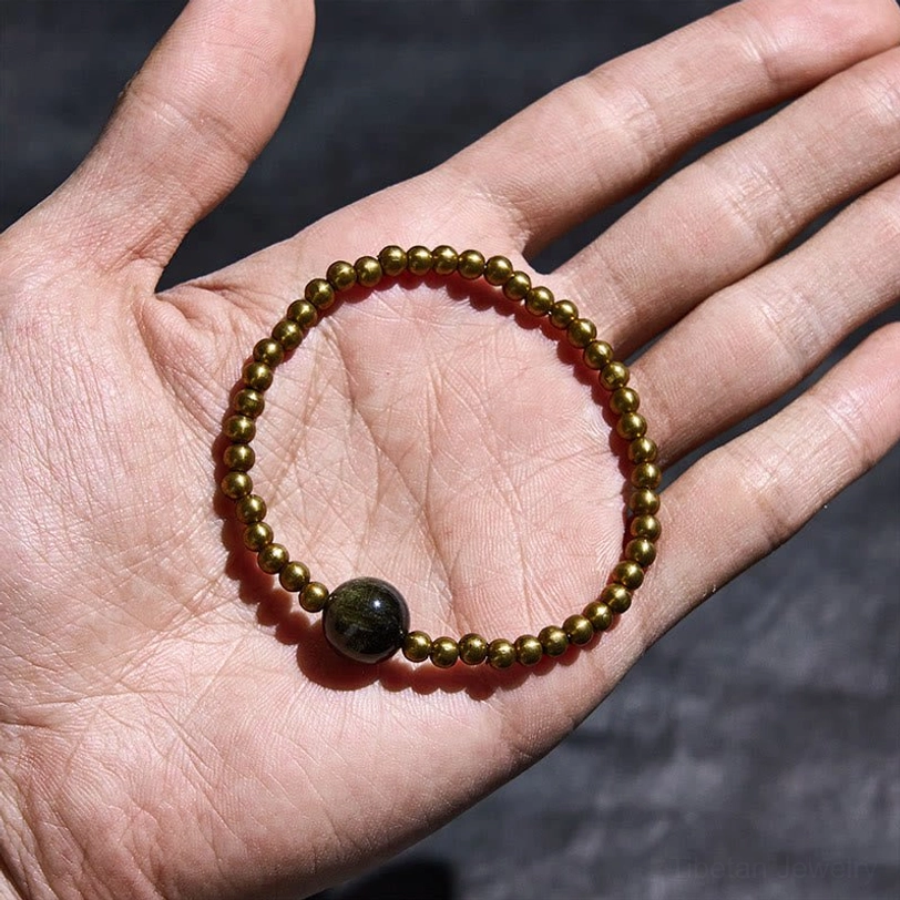 Copper brass obsidian beaded bracelet resting in palm hand display