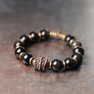 Single strand rainbow obsidian beaded bracelet with vintage bronze spacer rings close up detail