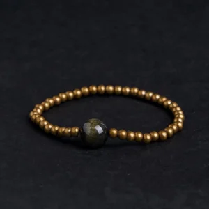Gold sheen obsidian copper brass beaded bracelet flat lay top view with dark focal stone