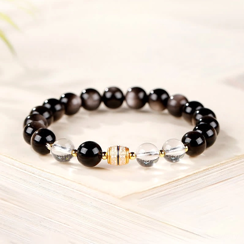Silver Sheen Obsidian Dzi Bead Bracelet neatly arranged on book page showing craftsmanship details