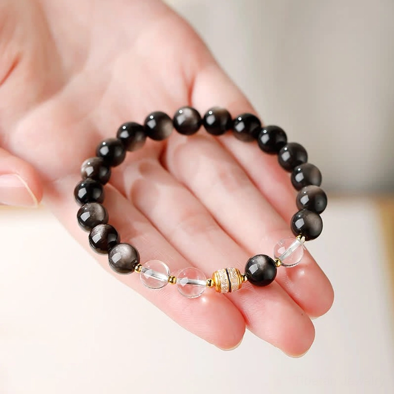 Silver Sheen Obsidian Dzi Bead Protection Bracelet held in palm showing actual size and bead clarity