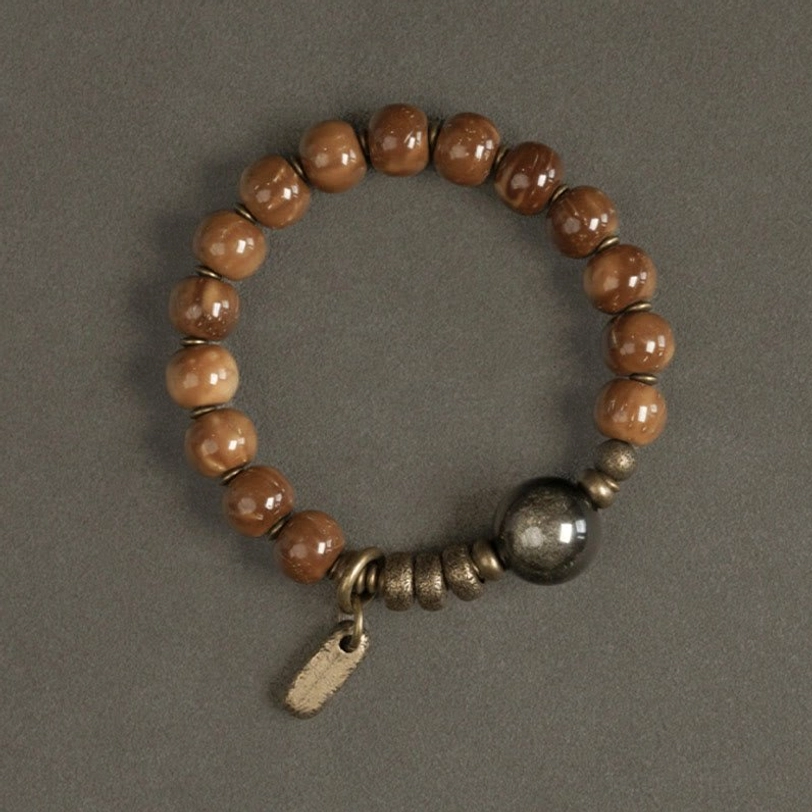Uniform warm brown beads with dark shiny gold sheen obsidian focal bead and branded tag