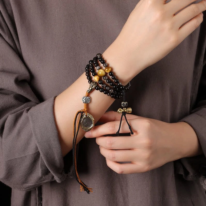 Obsidian Garuda protection necklace worn on wrist model view black and gold bead design