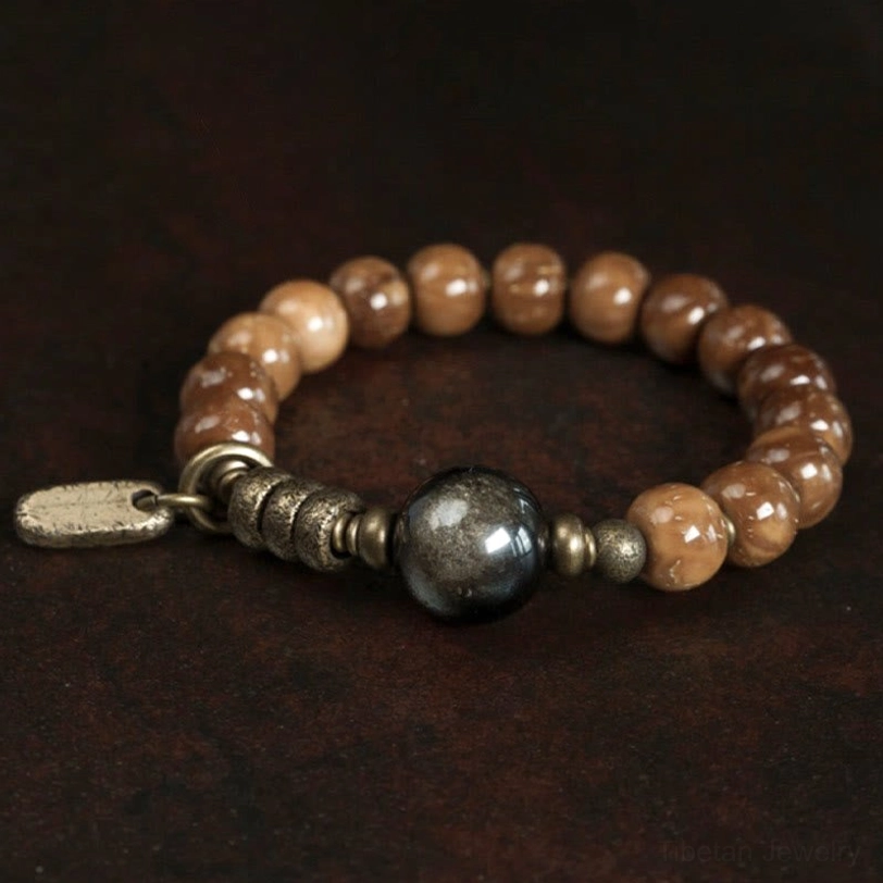 Gradient brown kuka seed beads with large dark obsidian central stone and brass hardware