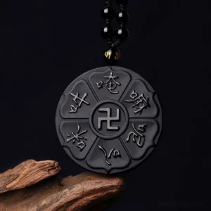Black obsidian Om Mani Padme Hum and swastika Tibetan Buddhist pendant necklace, top-down view with silver engraved details on dark background