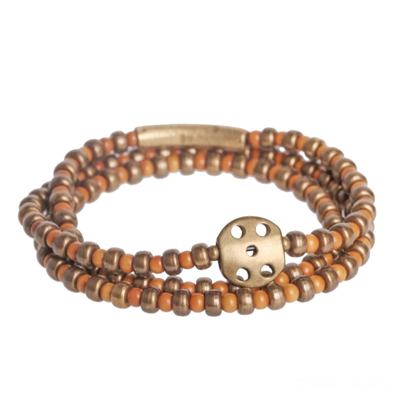 Multi-strand olive pit and brass wealth bracelet flat lay front view showing mixed warm brown and copper-toned beads on neutral background