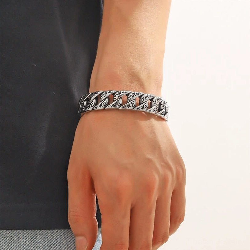 Tibetan Om Mani Padme Hum cuff bracelet worn on adult wrist, real-world wear perspective showing fit and vintage silver tone