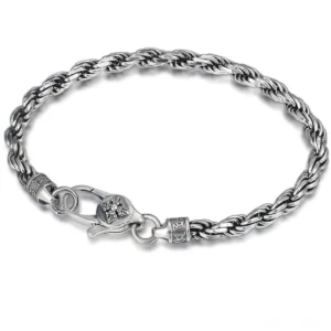 Overhead view of twisted rope sterling silver bracelet with Om Mani Padme Hum mantra and Double Dorje Vajra design on white background