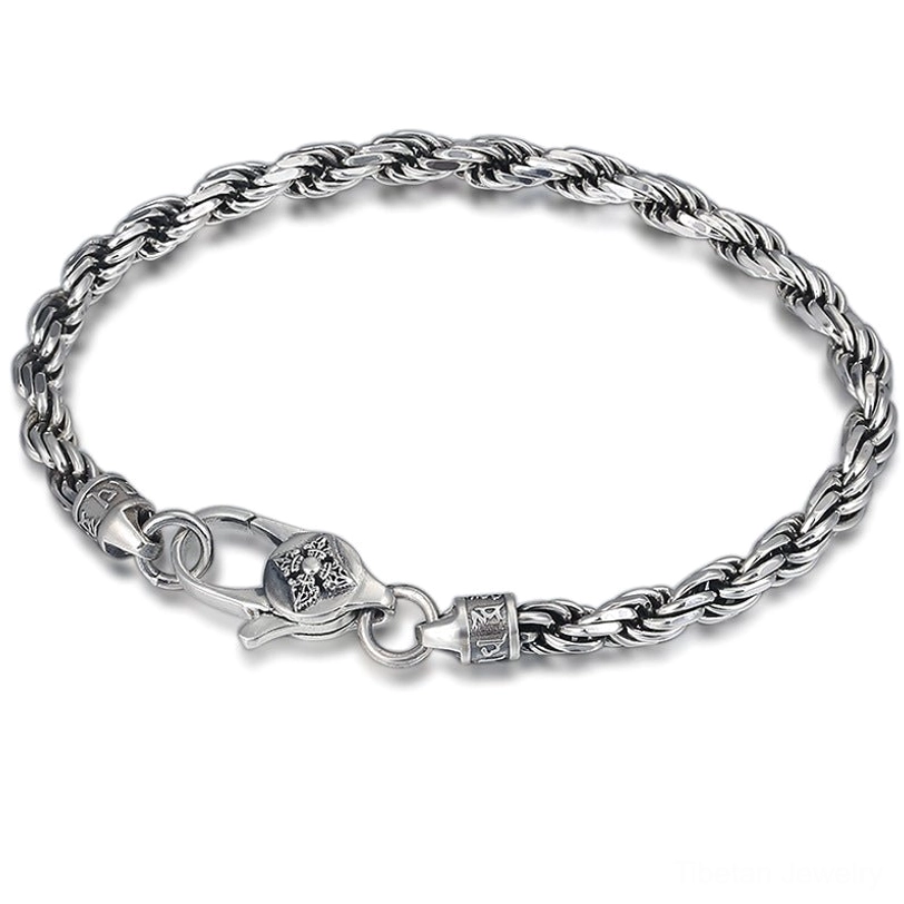 Overhead view of twisted rope sterling silver bracelet with Om Mani Padme Hum mantra and Double Dorje Vajra design on white background