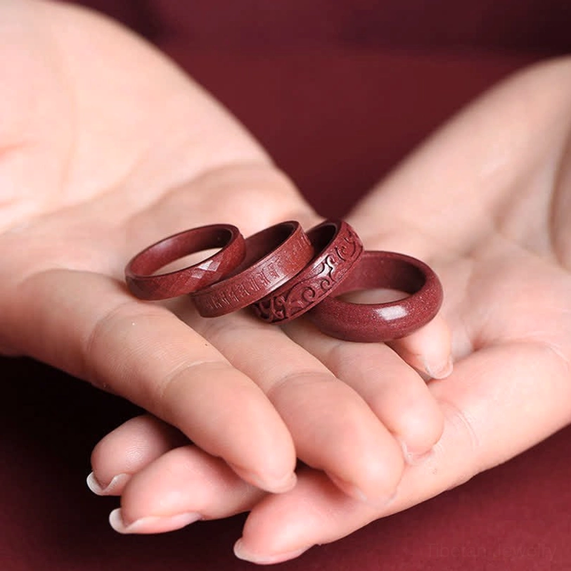 Om mani padme hum tibetan blessing ring detail shot highlighting sacred six-syllable mantra carving on cinnabar