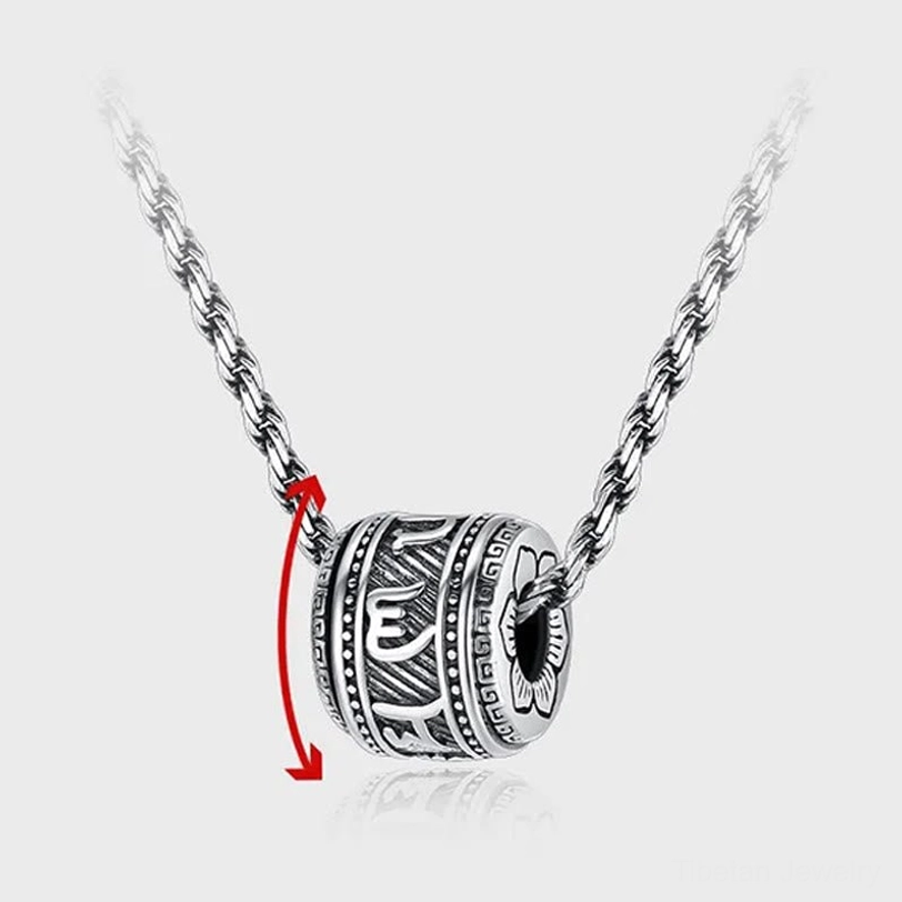 Close-up side view of rotatable Tibetan Om Mani Padme Hum barrel pendant showing detailed Sanskrit text engravings and rotation arrows