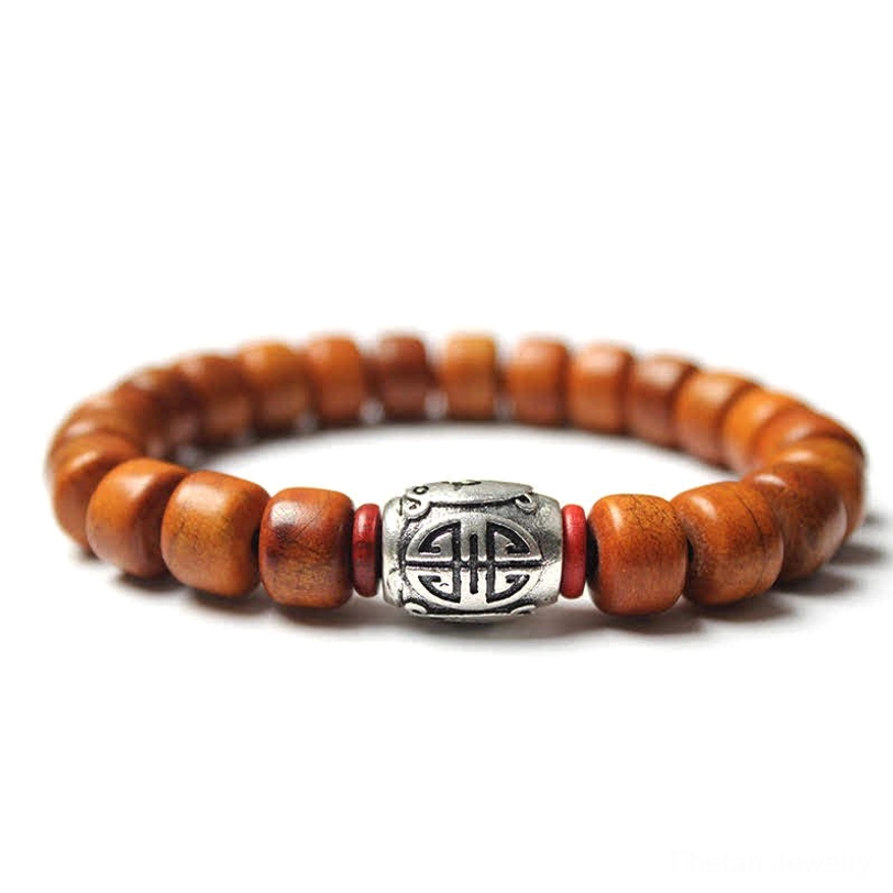 Om Mani Padme Hum bone bead bracelet with carved central bead and blue stone spacers on gray background