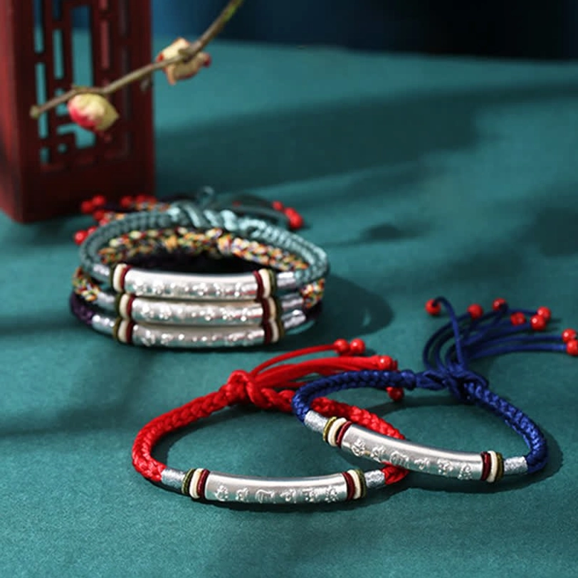 Collection of adjustable Om Mani Padme Hum string bracelets in various colors with silver components