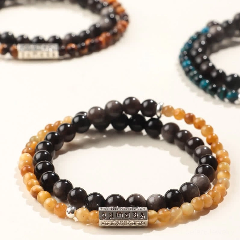Collection of three Om Mani Padme Hum double wrap bracelets in different colorways - obsidian, teal, and striped stone variations