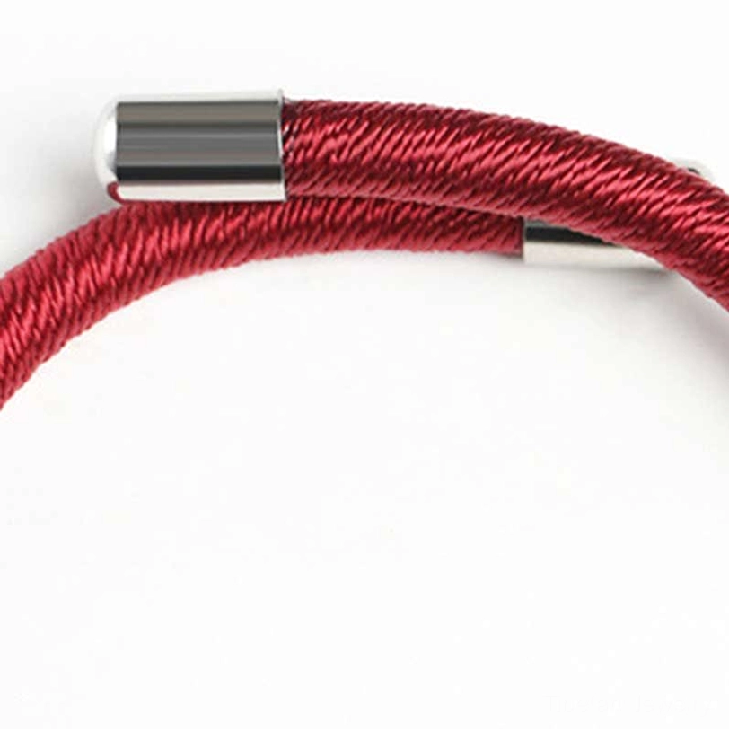 Partial view of Om Mani Padme Hum red cord bracelet showing woven thread and metal components