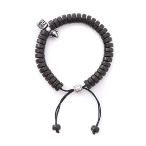 Handcrafted Tibetan coconut shell beaded bracelet, front flat view showing vintage silver vajra bell charm and black drawstring closure