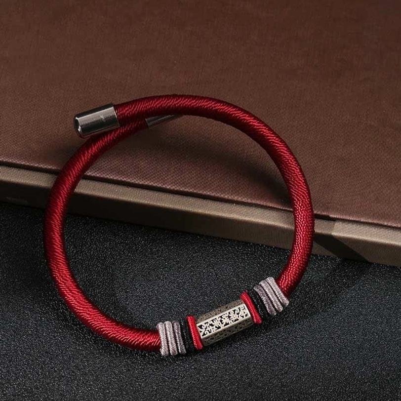 Close-up of Om Mani Padme Hum red bracelet magnetic metal caps and woven cord texture