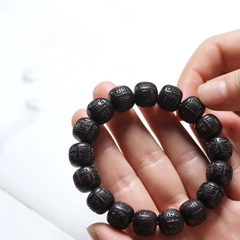 Handmade Tibetan bracelet resting on palm showing smooth wood texture and bead arrangement