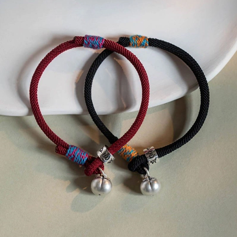 Red and black om mani padme hum persimmon charm bracelets with matching silver charms displayed together
