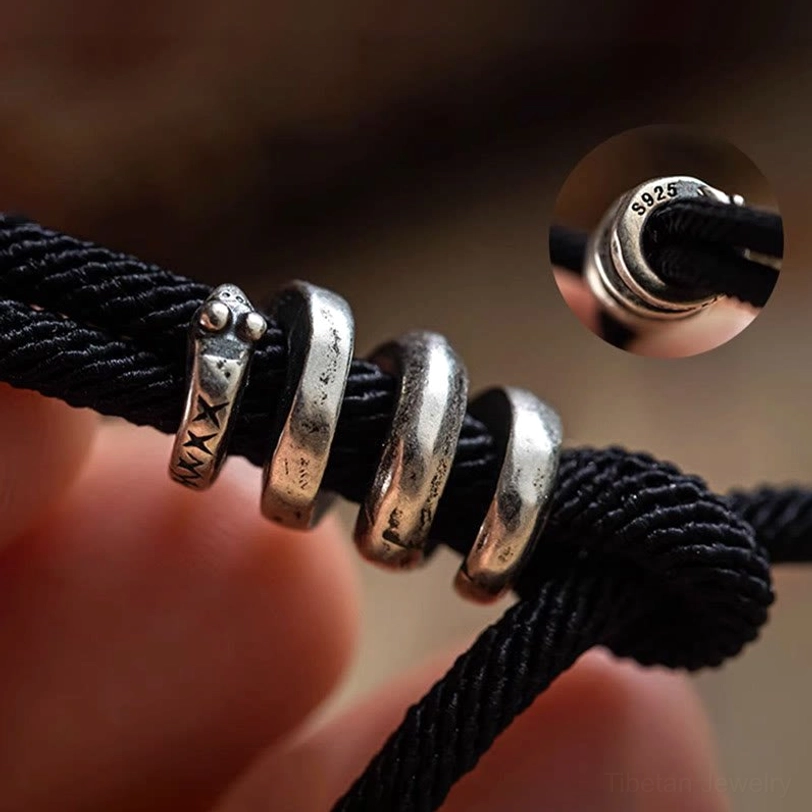 Tibetan bracelet fastener detail with S925 silver mark stacked metal rings and adjustable knot on skin