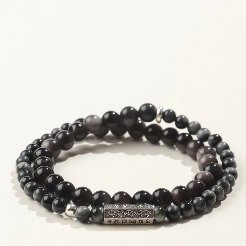 Overhead view of Silver Sheen Obsidian Om Mani Padme Hum bracelet with muted blue-gray beads and silver mantra charm