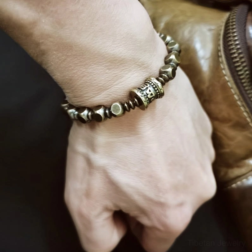 Om Mani Padme Hum bracelet worn on wrist showing on-body fit and authentic patina of brass