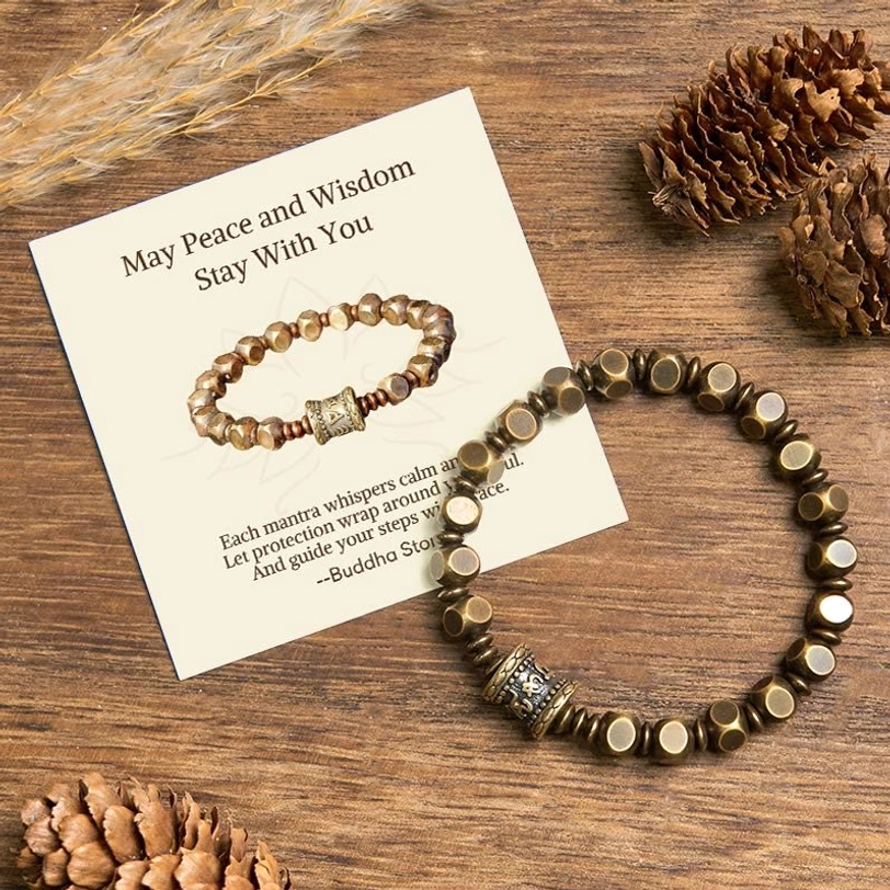 Om Mani Padme Hum brass amulet bracelet with gift message card on natural wood background with pine cones