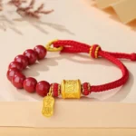 Om Mani Padme Hum sterling silver cinnabar blessing bracelet flat lay top view with gold mantra pendant on beige background