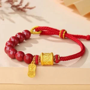 Om Mani Padme Hum sterling silver cinnabar blessing bracelet flat lay top view with gold mantra pendant on beige background