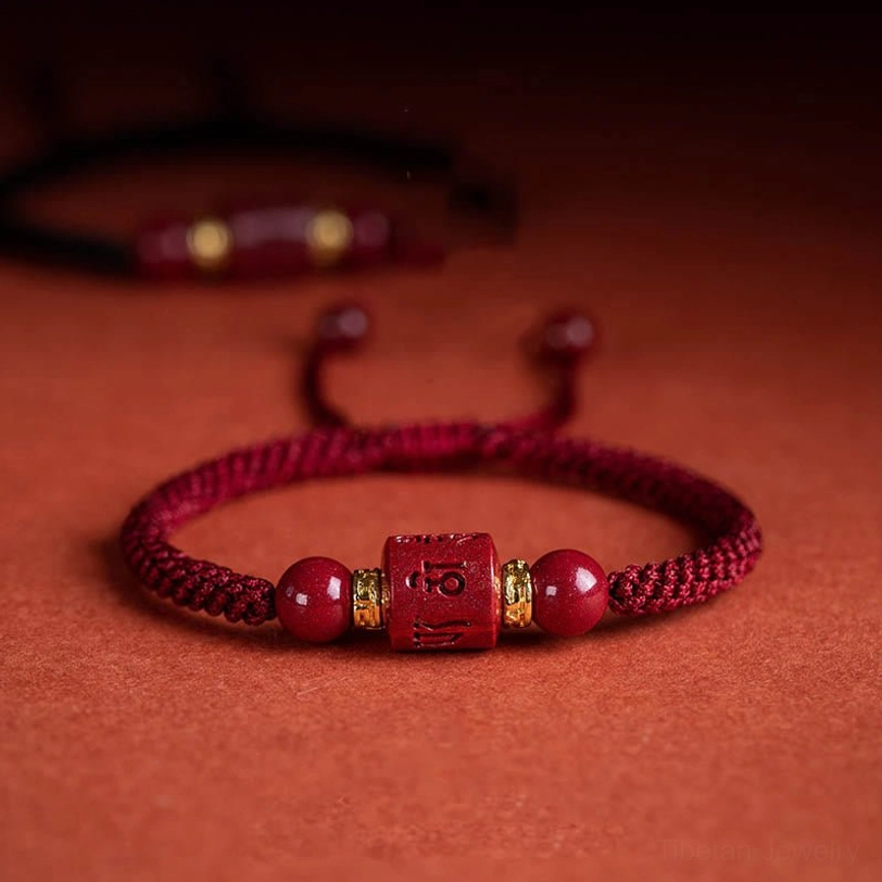 Tibetan Om Mani Padme Hum cinnabar blessing bracelet worn on wrist with traditional red clothing - real wearing effect side view