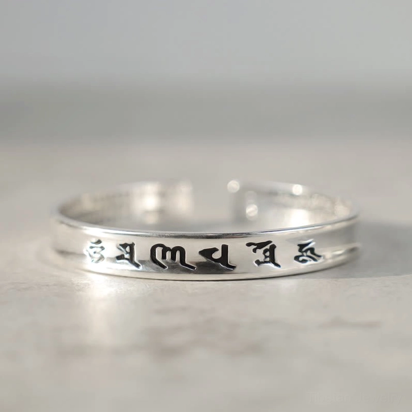 Om Mani Padme Hum white copper open cuff bracelet low-angle perspective showing polished silver finish and clear mantra engravings