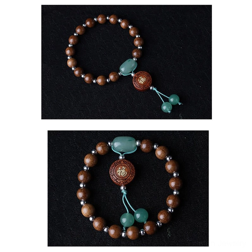 Overhead flat lay of abelia biflora wood protection bracelet with silver spacers, green jade bead, carved fu charm, and green tassel beads