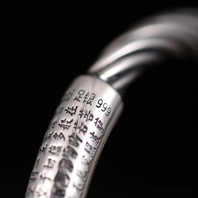 Close-up macro shot of engraved Tibetan Six True Words on copper bracelet