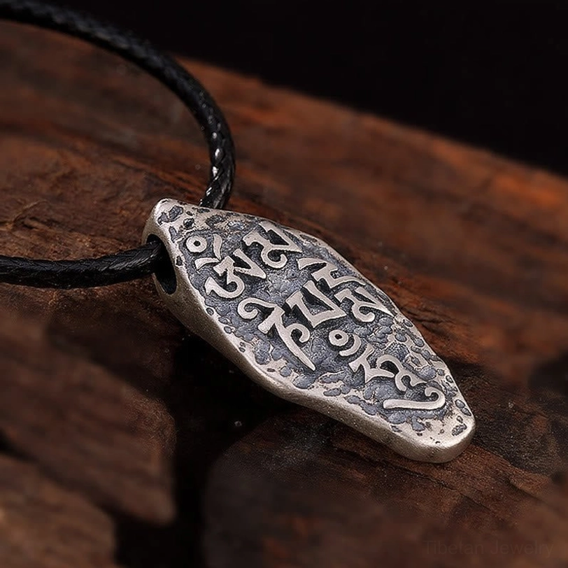 Full Sanskrit mantra engraved on Tibetan sterling silver Om Mani Padme Hum pendant, overhead view