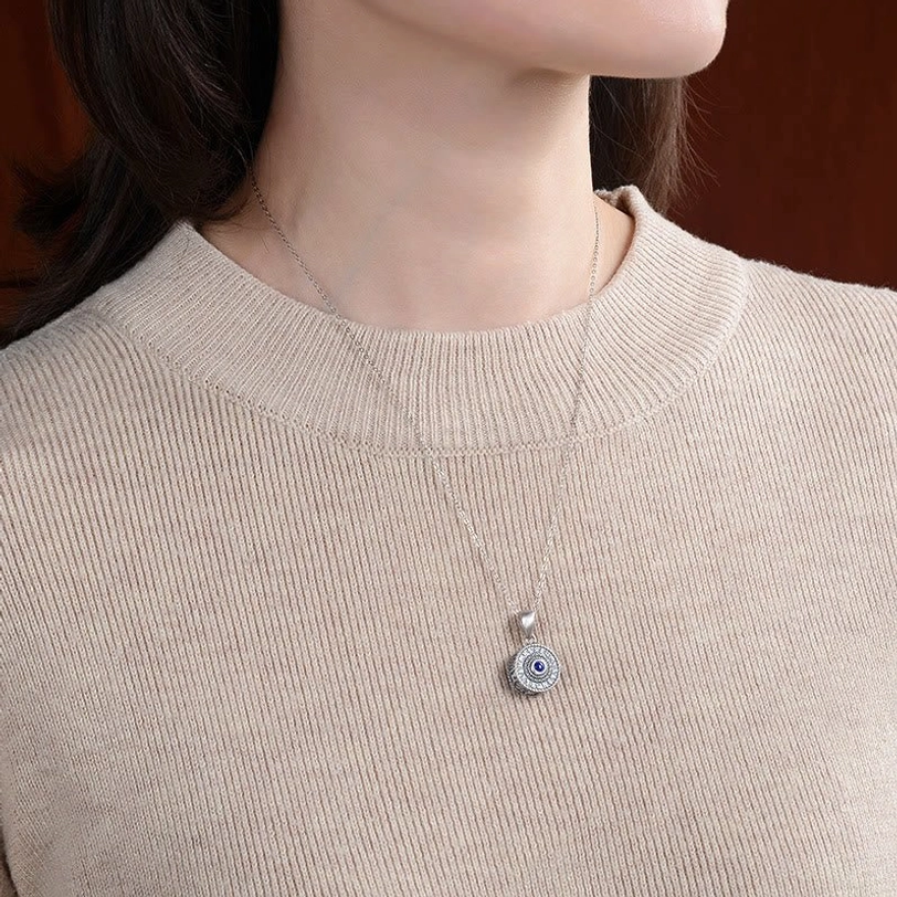 Tibetan Om Mani Padme Hum Sterling Silver necklace worn on person in beige knit sweater, showing how the delicate blue lapis lazuli pendant sits on thin silver chain for everyday wear