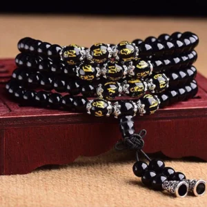 Close-up detail of Six True Words Om Mani Padme Hum obsidian mala with gold-engraved sacred Sanskrit symbols and silver metal hardware
