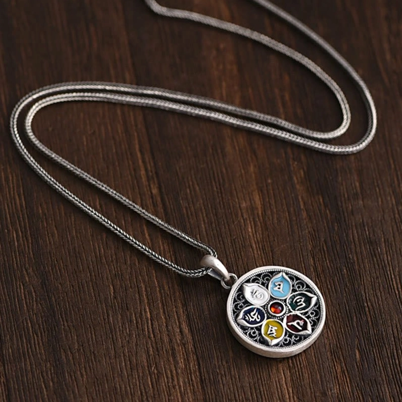 Complete Om Mani Padme Hum necklace set with snake chain and compact round pendant on dark wooden desktop