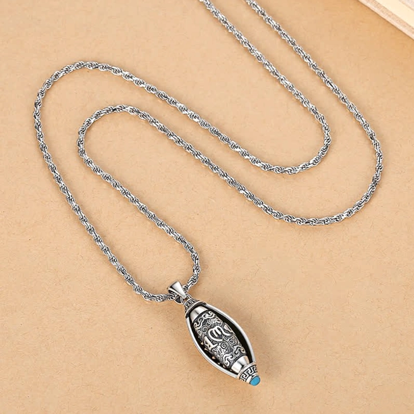Complete Tibetan Om Mani Padme Hum necklace set with long twisted silver chain and vintage pendant on wooden surface flat lay